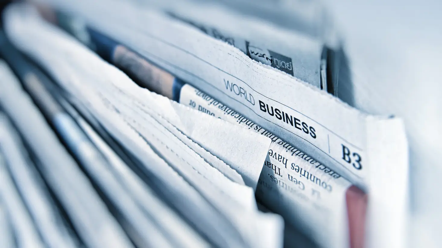 Folded business newspapers, representing sponsored article placements on major news sites