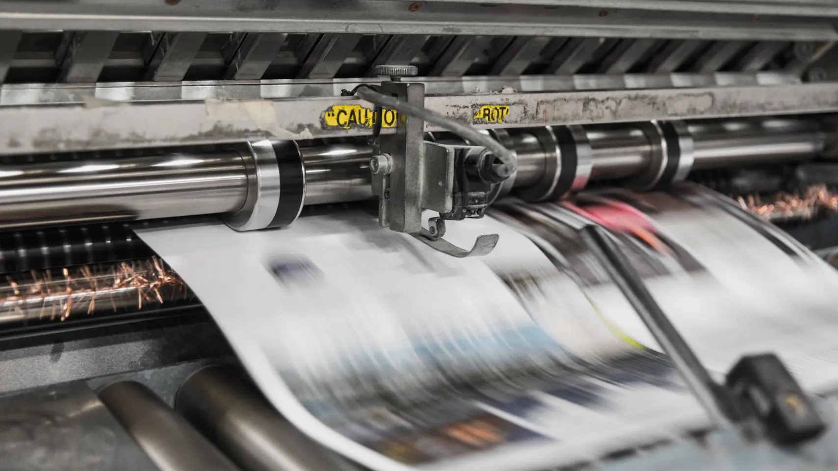 Newspaper printing press in motion, illustrating press release distribution to news sites