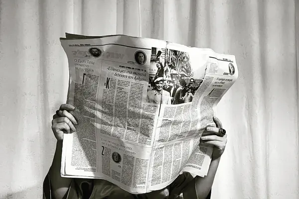 Person reading an open newspaper at a table for the parasite SEO guide